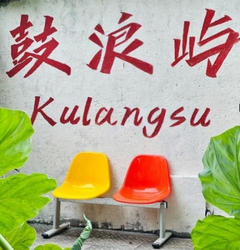 Gulangyu cultural activities hotel courtyard with two wooden chairs under a banyan tree in Kulangsu